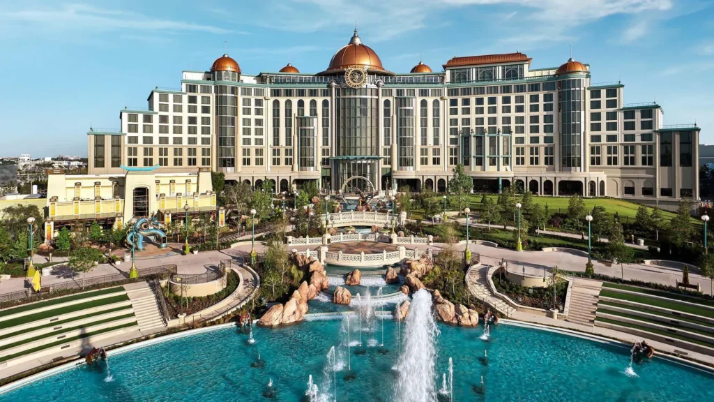 Vue du Universal Helios Grand Hotel avec son architecture élégante, ses jardins paysagers et ses fontaines à Epic Universe à Universal Orlando Resort.